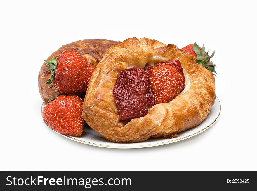 A plate of pastries, danish and strawberries isolated on white. A plate of pastries, danish and strawberries isolated on white.