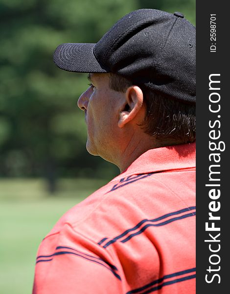 A male golfer studying the lay of a golf course - portrait, profile. A male golfer studying the lay of a golf course - portrait, profile.