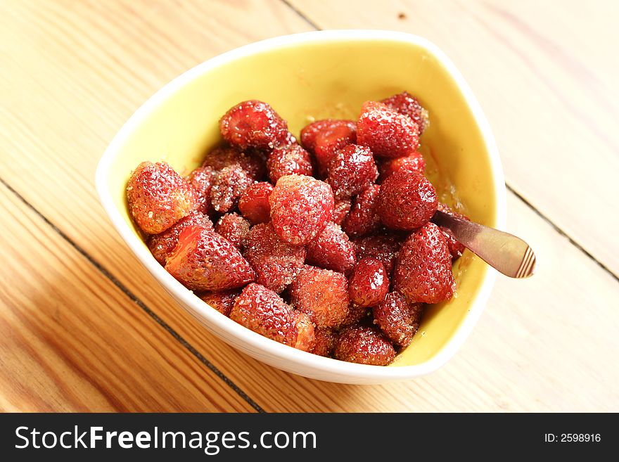 Sugared strawberries in a yellow bowl