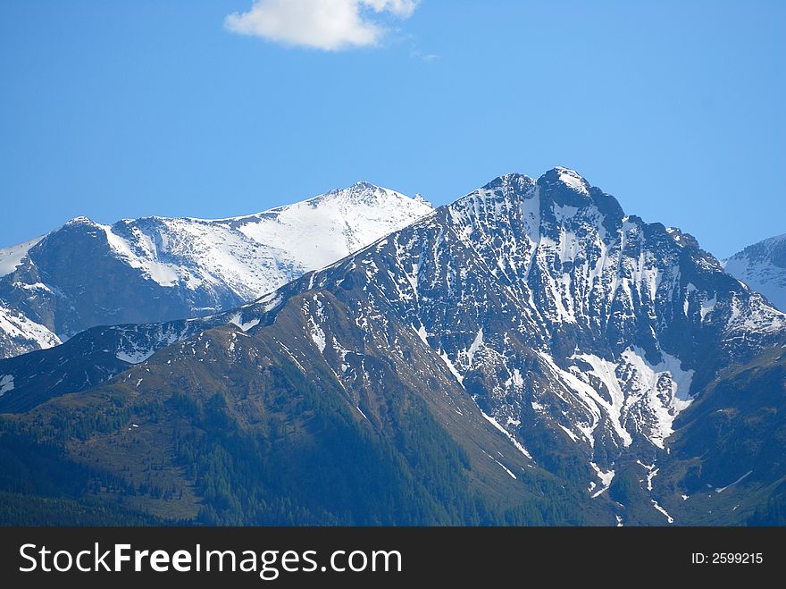 Alps double-head peak with snow on the sky background