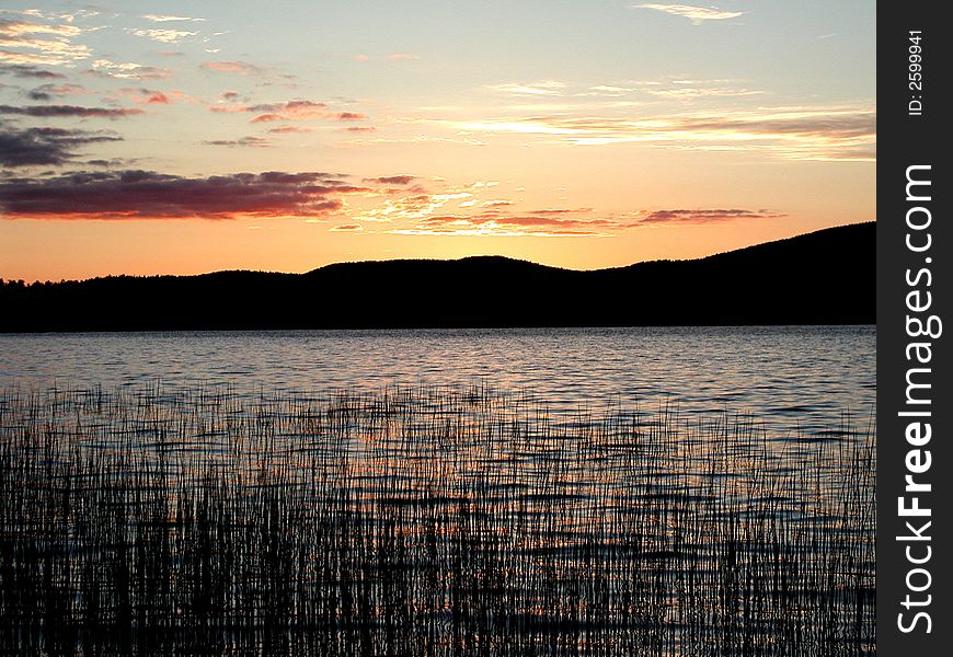 A calm summer sunset on a peaceful lake. A calm summer sunset on a peaceful lake