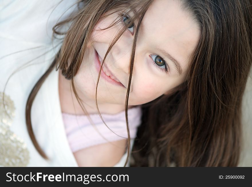 Angled natural portrait of sweet little girl with long brown hair and green eyes. Angled natural portrait of sweet little girl with long brown hair and green eyes