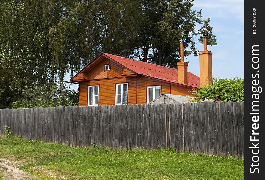 New country house behind a high wooden fence. New country house behind a high wooden fence