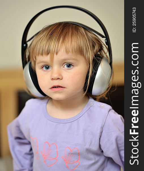 A little girl listening music with headphones. A little girl listening music with headphones