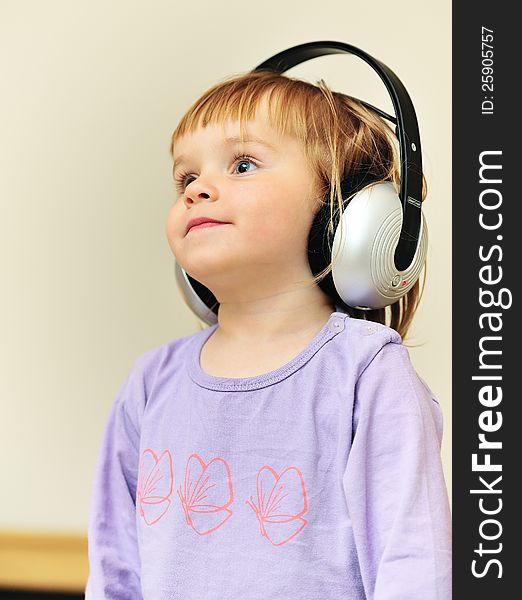 Little girl listening to music with headphones