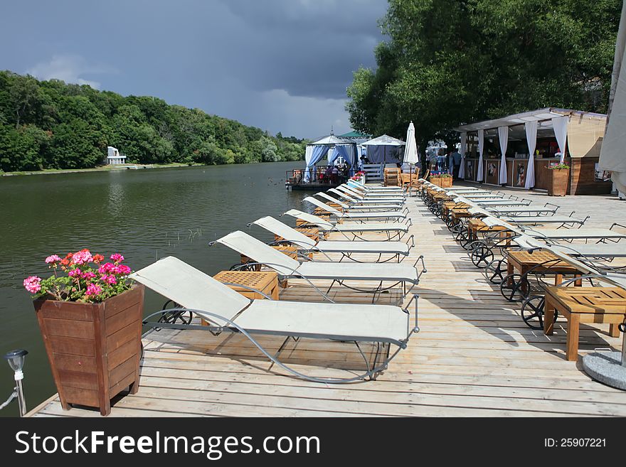 A Lounge chairs on a wooden pier. Moscow river. A Lounge chairs on a wooden pier. Moscow river