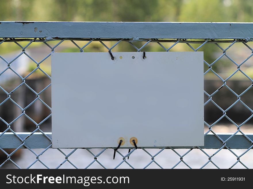 Blank metal sign on metal fence. Blank metal sign on metal fence.