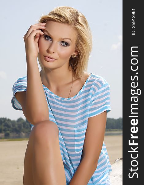 Portrait of beautiful blonde girl on background blue sky. Portrait of beautiful blonde girl on background blue sky