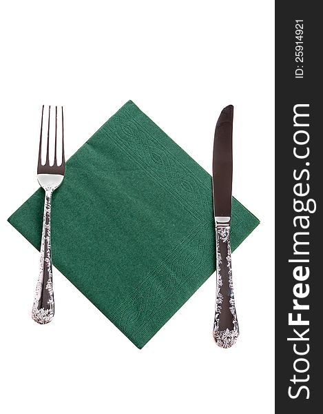 Fork and a knife lying on the green on a white napkin. Fork and a knife lying on the green on a white napkin