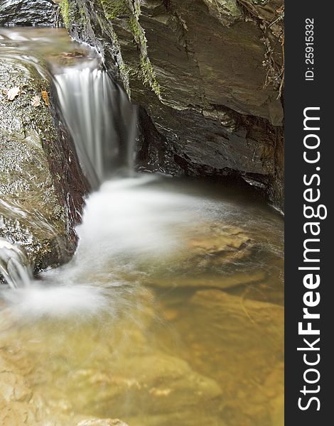 Small weir flowing over rocks in rock. Small weir flowing over rocks in rock