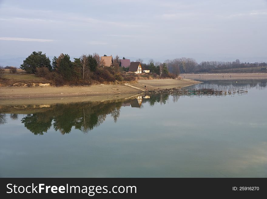 Launched dam calm surface, fishing houses on the shore