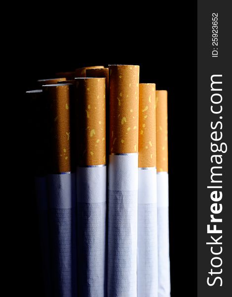 Cigarettes on a black background with a single light source to stress the bad effects of smoking. Cigarettes on a black background with a single light source to stress the bad effects of smoking