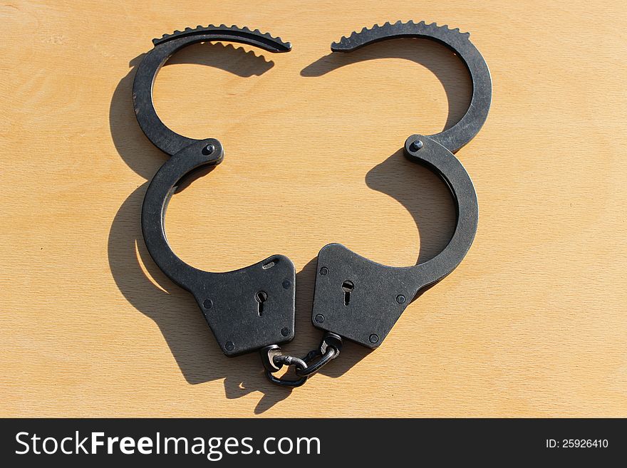 Open Handcuffs closeup on wooden table