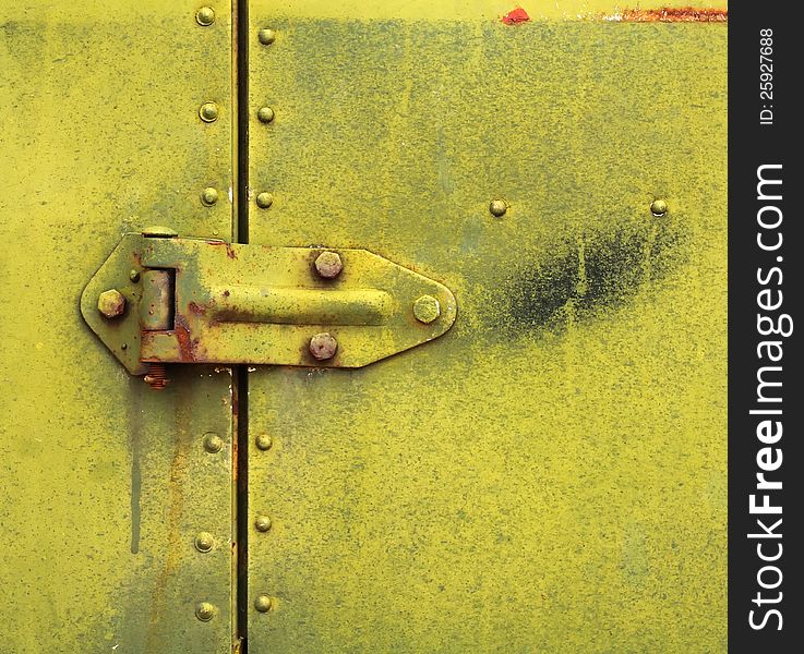 A hinge on a rusty metal door. A hinge on a rusty metal door