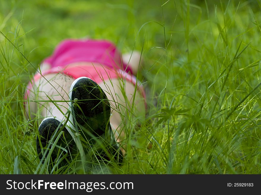 Girl lying on green grass (bottom view). Girl lying on green grass (bottom view)