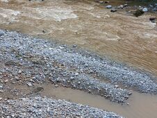 A Muddy Stream Gushing Past A Rocky Terrain Stock Photography