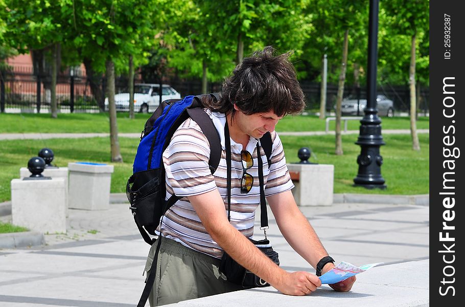 Tourist with long dark hair is oriented in the city and looking to the map