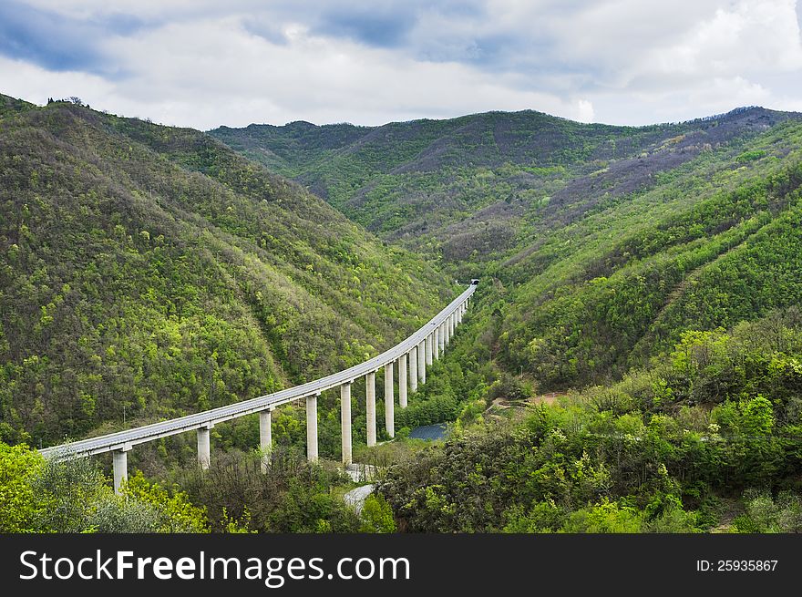 An elevated road among beautiful green mountains. Perfect for environment/transportation concepts. An elevated road among beautiful green mountains. Perfect for environment/transportation concepts.