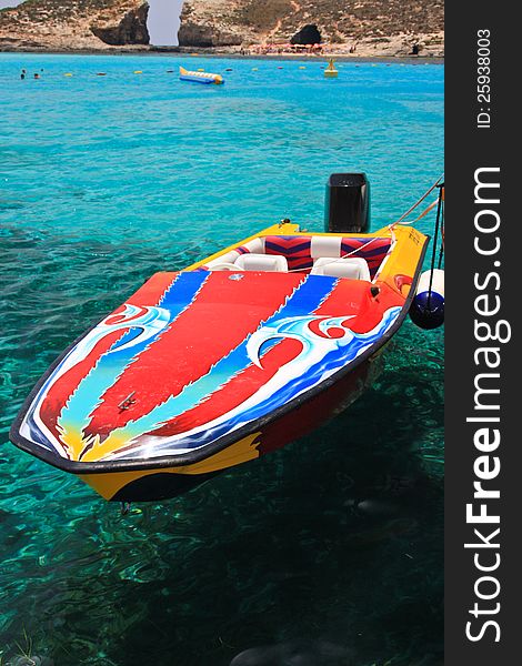 Colourful speed boat floating on turquoise water near Blue Lagoon, Malta. Colourful speed boat floating on turquoise water near Blue Lagoon, Malta.