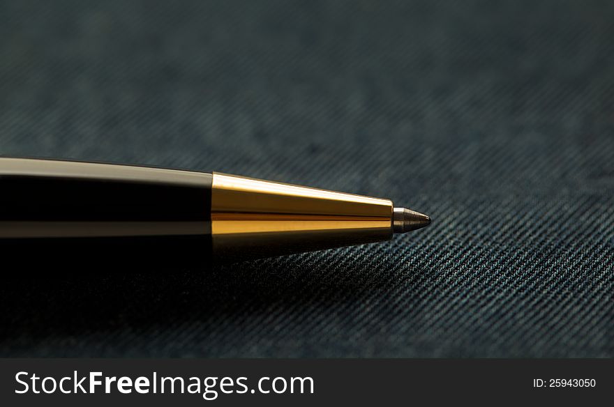 Black and Golden ball Pen over textured background