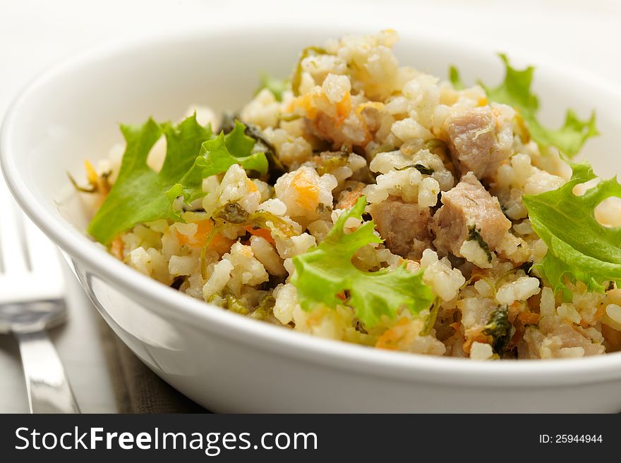 Rice with pork, carrots and spinach. Close Up view