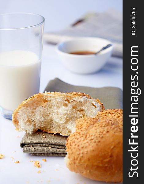 Portion loaf with sesame and milk on background
