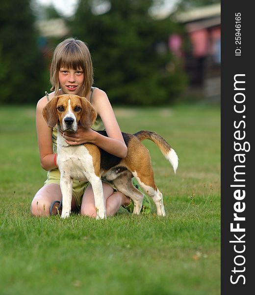 Girl and her beagle sitting in the grass. Girl and her beagle sitting in the grass.