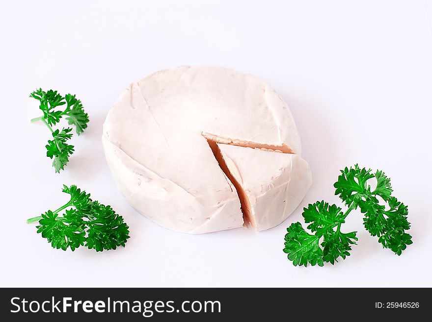 Close-up of a round Camembert with parsley   on white. Peace of cheese. Close-up of a round Camembert with parsley   on white. Peace of cheese.