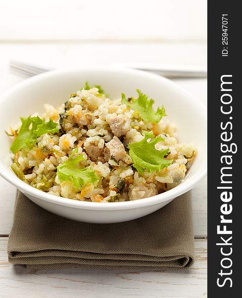 Rice with pork, carrots and spinach on a olive napkin