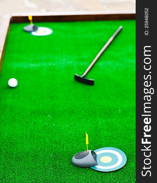 Mini golf field with ball and golf club