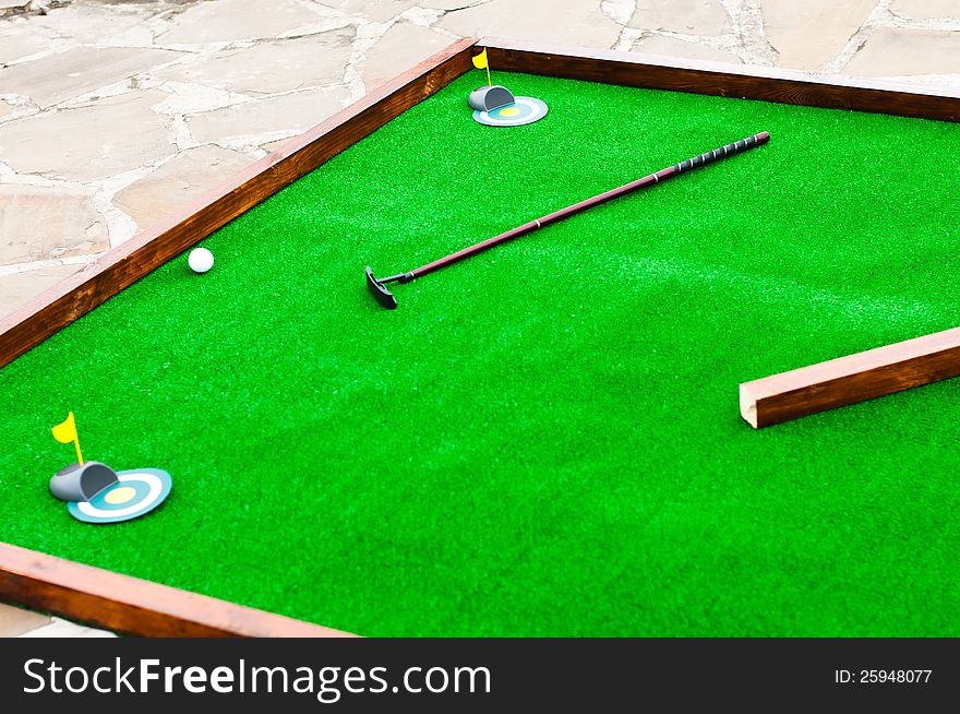 Mini golf field with ball and golf club