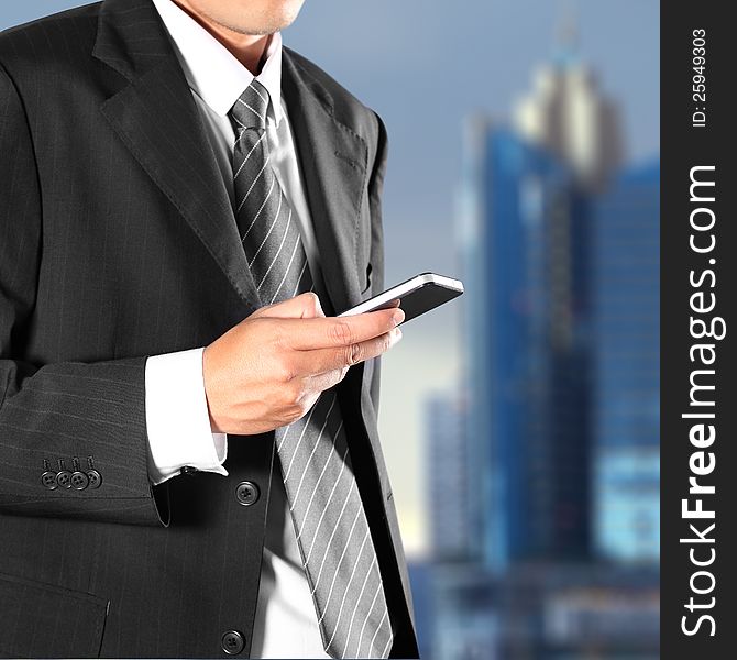 Cropped view of Businessman holding the phone standing in front the major cities