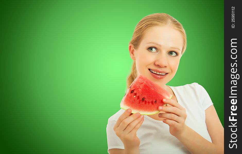 Healthy pretty girl with a slice of watermelon on a green background