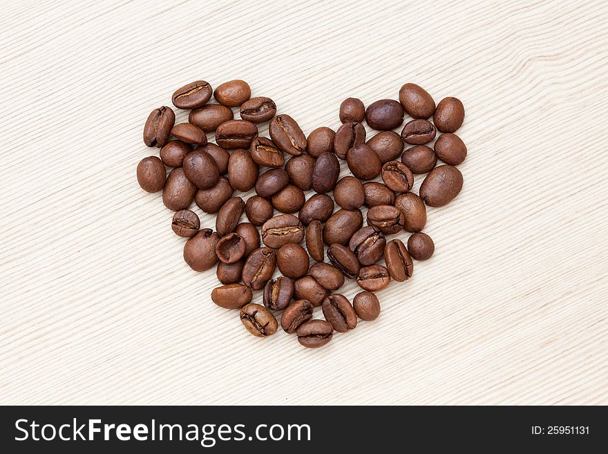 Coffee beans on light wood background. Coffee beans on light wood background