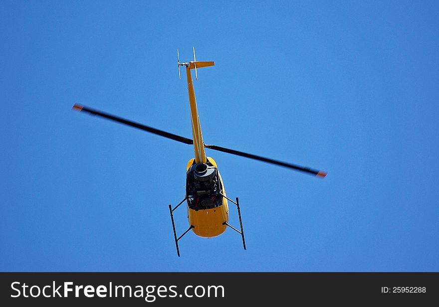 A helicopter in flight against a blue background.