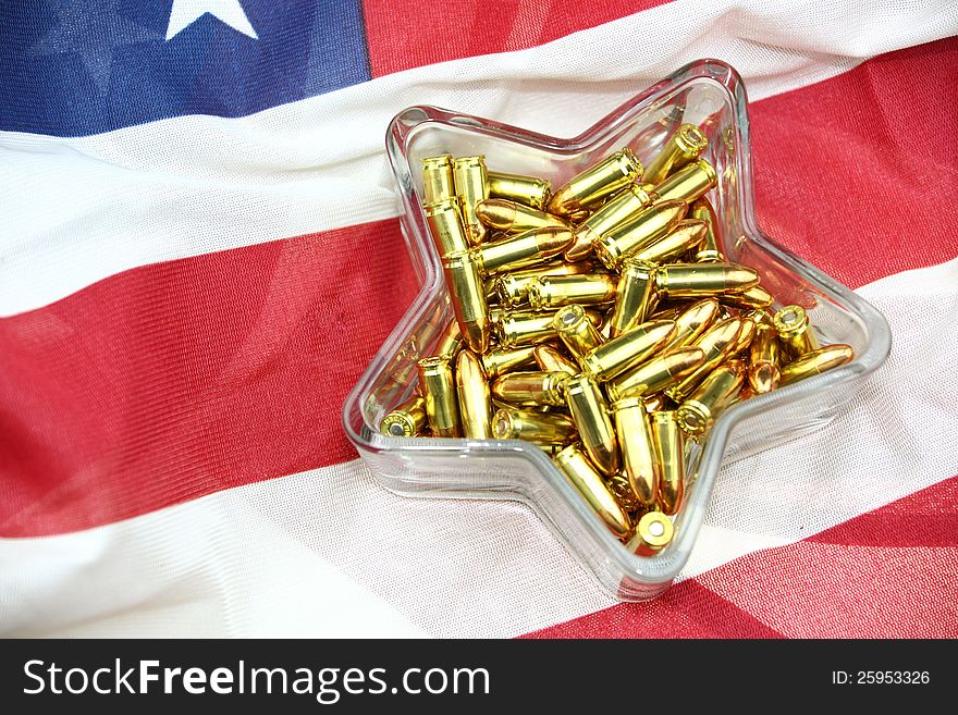 9mm ammunition in star shaped glass candy dish resting on an American flag. 9mm ammunition in star shaped glass candy dish resting on an American flag