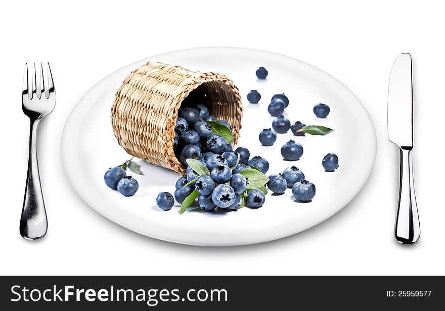 Blueberries fall of the basket on a plate. White background.