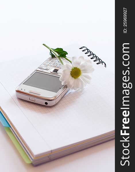 Notebook,mobile phone and flower isolated on white