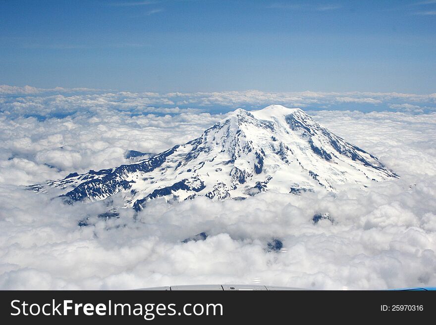 The majestic peak of Mt Rainier towering above the clouds