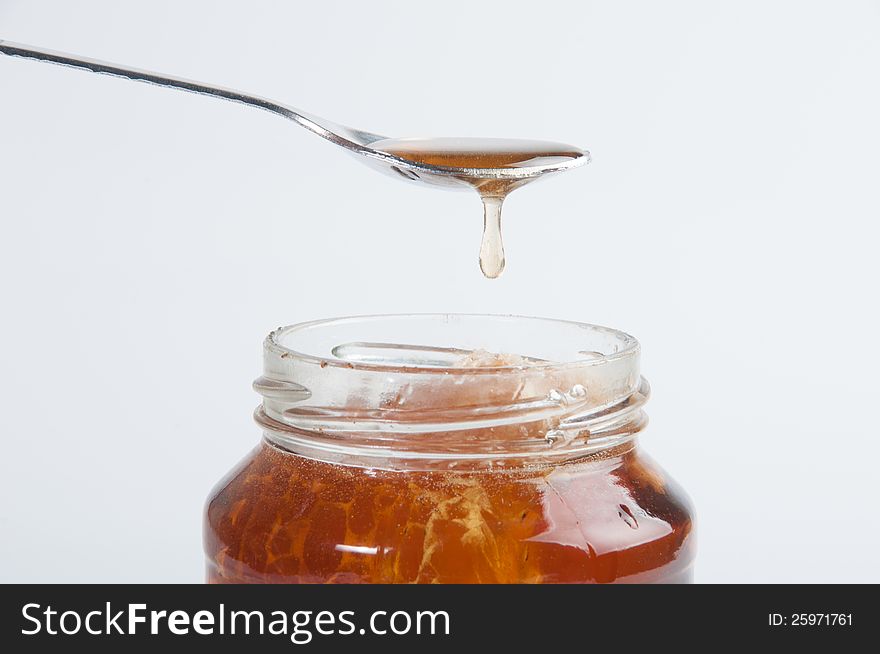 The glass honey jar and white background