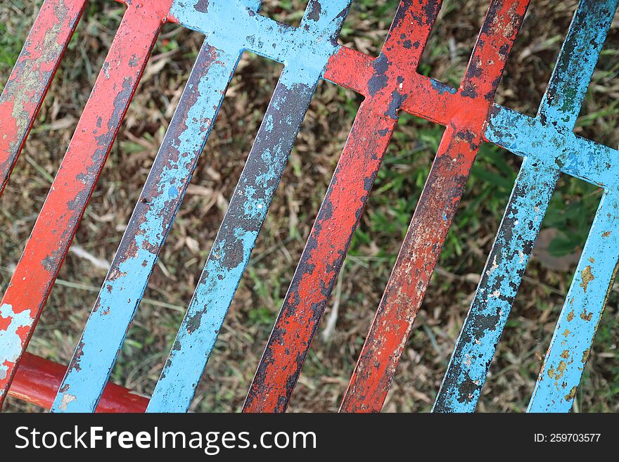 A Photo Of A Iron Trellis With Red And Blue Paint That Has Peeled Off