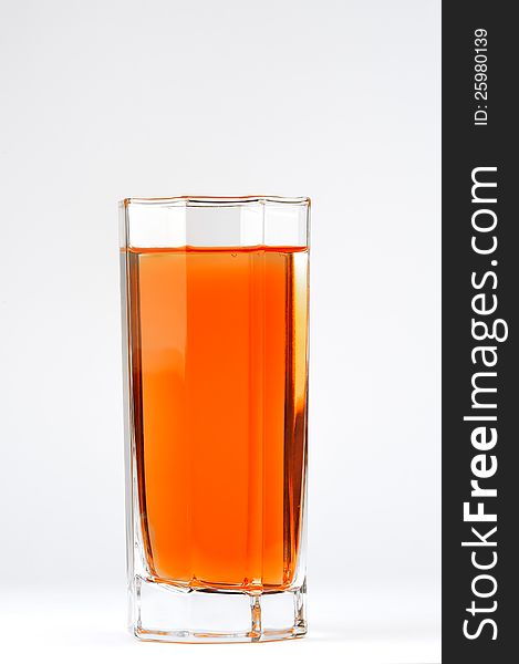 A glass with a red drink on a white background