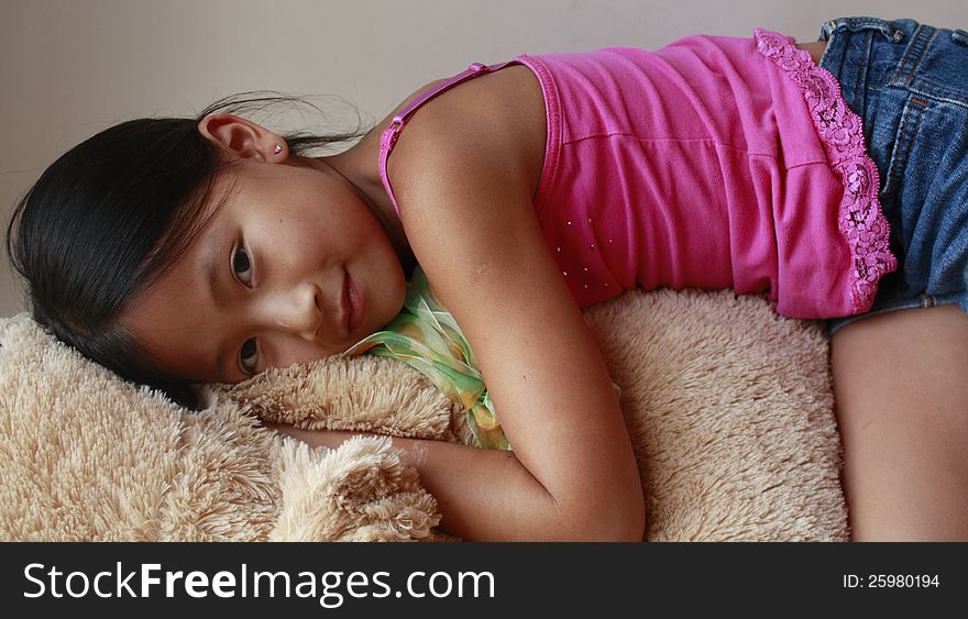 Chinese Asian girl laying on a big stuffed animal. Chinese Asian girl laying on a big stuffed animal