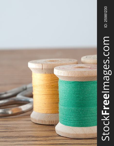 Three spools of thread and scissors in close focus