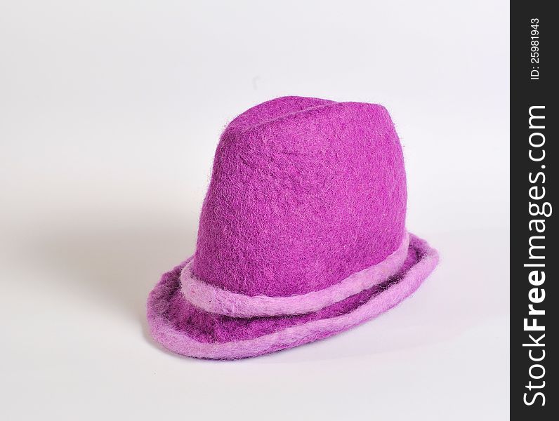 On a white background lie a felt violet hat. On a white background lie a felt violet hat