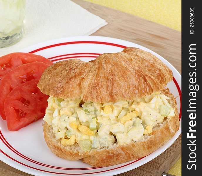 Egg sakad sandwich on croissant roll with sliced tomatoes. Egg sakad sandwich on croissant roll with sliced tomatoes