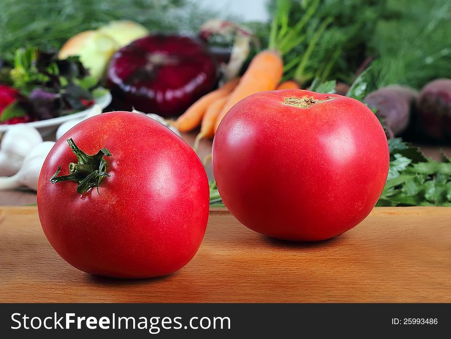 Fresh tomatoes, close-up on the background of vegetables