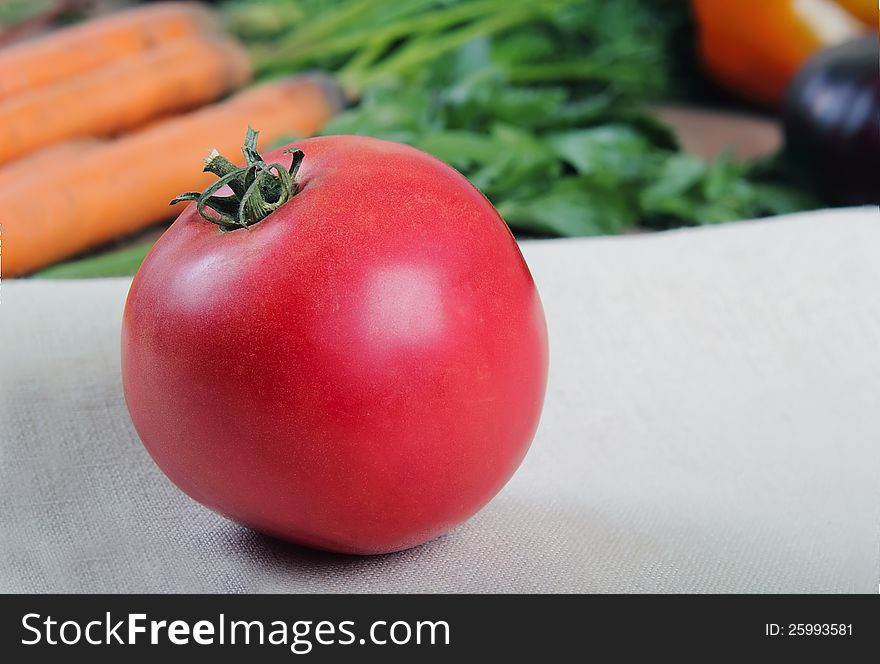 Fresh tomatoes, close-up on the background of vegetables