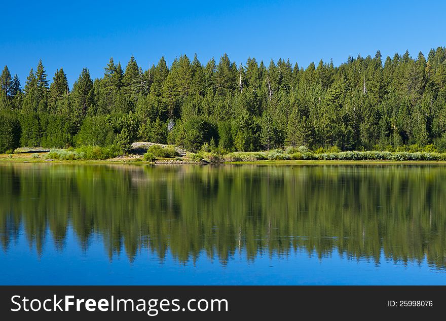 High sierra lake with mirror reflection and blue skies. High sierra lake with mirror reflection and blue skies