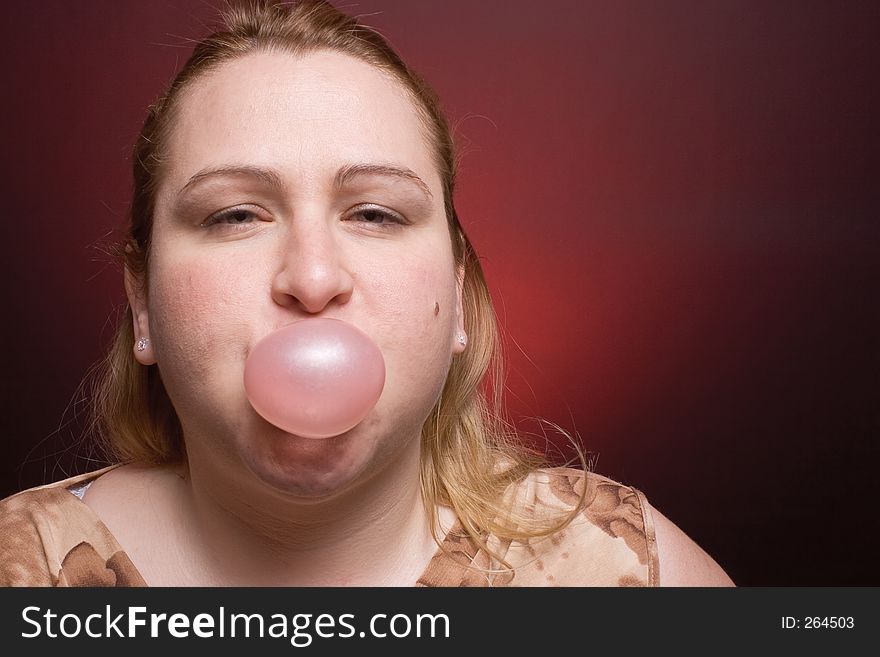 Women blowing small bubble gum. Women blowing small bubble gum